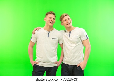The two happy twin brother stand on the green background - Powered by Shutterstock