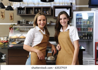 Two Happy Waitresses Working At A Cafe