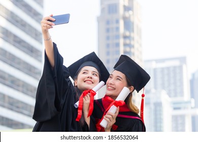 Two Happy Women In Graduation Gowns Making Selfie, Capturing Happy Moments.