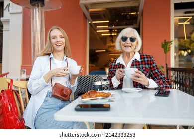 Two Happy Women Having Coffee At Sidewalk Cafe