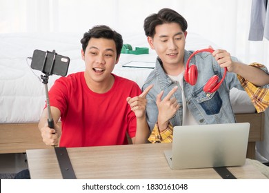 Two happy Young Asian men influence blogger present and review product on live streaming broadcast with internet subscribers. Social media people content maker, LGBTQ couples working together concept. - Shutterstock ID 1830161048