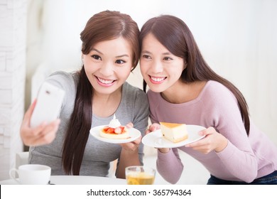 Two Happy Young Female Friends Take Selfie Picture By Smart Phone, With Coffee Cups And Cakes In The Living Room At Home, Healthy Lifestyle Concept, Asian Beauty