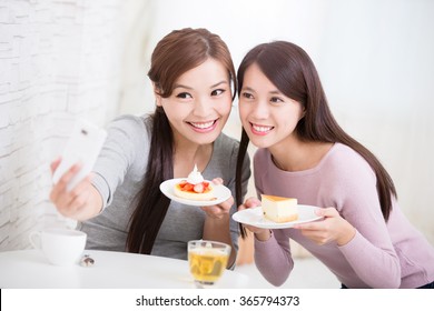 Two Happy Young Female Friends Take Selfie Picture By Smart Phone, With Coffee Cups And Cakes In The Living Room At Home, Healthy Lifestyle Concept, Asian Beauty