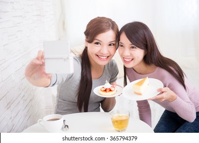 Two Happy Young Female Friends Take Selfie Picture By Smart Phone, With Coffee Cups And Cakes In The Living Room At Home, Healthy Lifestyle Concept, Asian Beauty