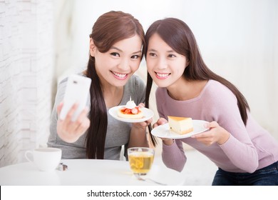 Two Happy Young Female Friends Take Selfie Picture By Smart Phone, With Coffee Cups And Cakes In The Living Room At Home, Healthy Lifestyle Concept, Asian Beauty