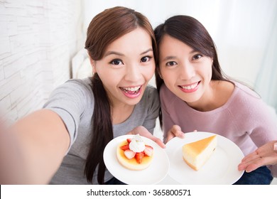 Two Happy Young Female Friends Take Selfie Picture With Coffee Cups And Cakes In The Living Room At Home, Asian Beauty