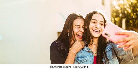 two happy young Hispanic women together taking a selfie with copy space. friendship concept. young girls friends happiness.