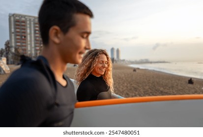 Two happy young surfers with surfboard prepares to hit the waves at sunset. Sports active vacation - Powered by Shutterstock