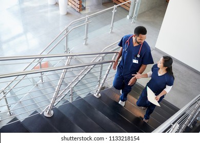 Two healthcare colleagues talking on the stairs at hospital
