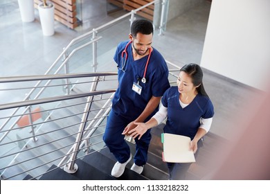 Two healthcare colleagues talking on the stairs at hospital - Powered by Shutterstock