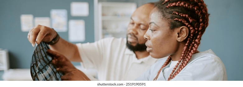 Two healthcare professionals examining medical scans in clinical environment with focused attention, discussing results of patient's condition and potential treatments - Powered by Shutterstock