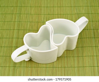 Two heart shaped empty cups over the green mat
