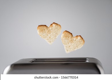 Two heart shaped toast bread roasted toasted in a toaster. Breakfast preparation on Valentine's Day. symbol sign of love. Concept  
