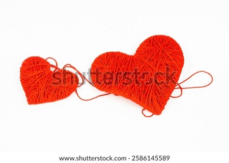 Two hearts of different sizes made of red threads, on a white background