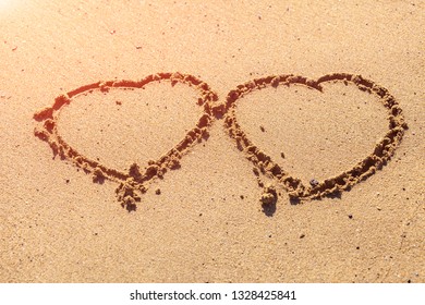 Two hearts drawn in the sand on the beach. Image for a romantic trip, honeymoon, relaxing at sea, vacation. - Powered by Shutterstock