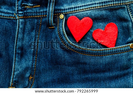 two hearts on a background of a jeans pocket close-up.Valentines Day background consept.