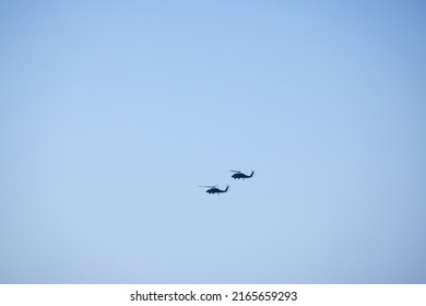 Two Helicopters Flying In Formation