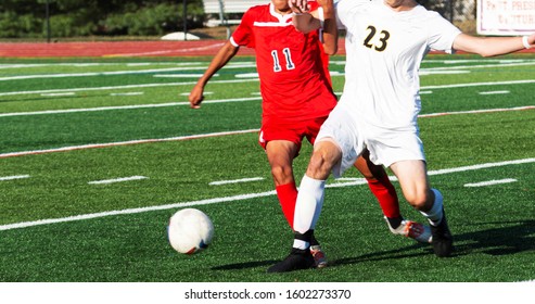 Two High School Boys Draw Contact With Each Other During A High School Soccer Game On A Green Turf Field, 