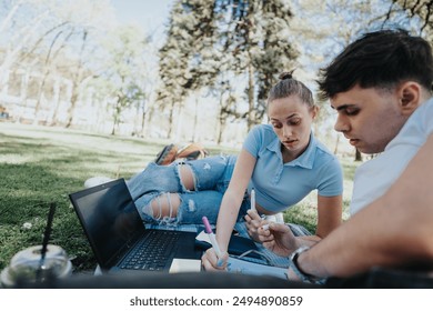 Two high school students are engaged in studying and doing homework together, offering mutual help while sitting comfortably in a lively urban park setting.