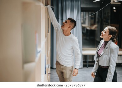 Two high school students are exploring books on a library shelf, showcasing curiosity and learning in an educational environment. They appear engaged and focused, embodying school life and academic