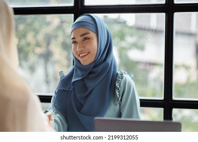 Two Hijab Asian Women Shaking Hands After A Startup Company Meeting. Run By A Young, Talented Woman. The Management Concept Runs The Company Of Female Leaders To Grow The Company.