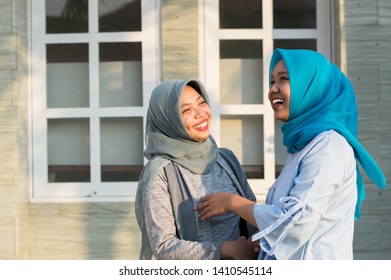 Two Hijab Women Neighbors Meet And Say Hi While Smiling And Shake Hands In Front Of Their House On A Sunny Day