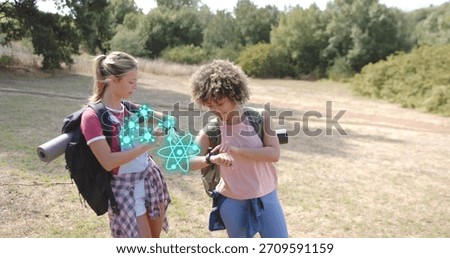 Two hikers checking watch in grassy clearing near trail, packs with mats, plaid at waist, hologram. Backpack, hiking, outdoor, nature, wellness, augmented, reality
