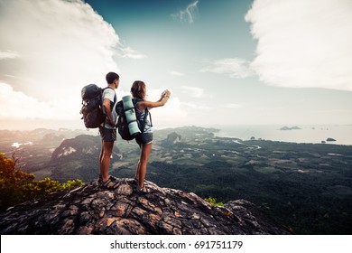 Two hikers relax on top of a mountain with great view - Shutterstock ID 691751179