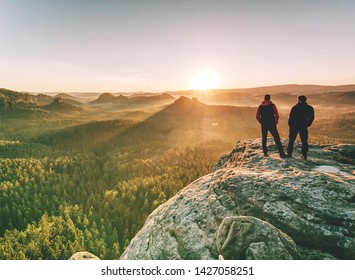 Zwei Wanderer, die auf dem Gipfel über dem Tal in den Bergen stehen. Männer diskutieren Tagesplan, genießen schöne Aussicht