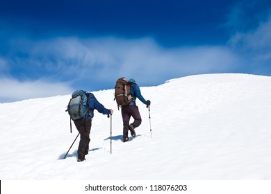 Two of hikers walking up in the mountains