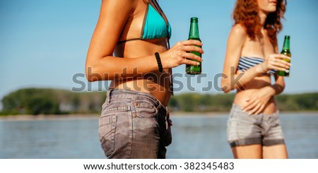 Two Hipster Females At The Beach Drinking Beer