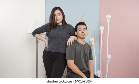 Two Hipster Models Man And Woman Wearing Blank Gray T-shirt, Jeans And  Posing Against Colorfull Wall In The Studio, Front Tshirt Mockup For Couple, Urban Style