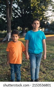 Two Hispanic Boys Holding Hands In The Woods, Brothers Together,