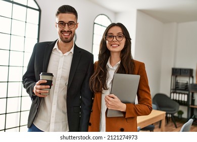 Two hispanic business workers smiling happy drinking coffee at the office. - Shutterstock ID 2121274973