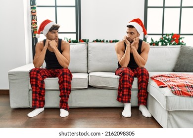 Two Hispanic Men Couple Arguing Sitting By Christmas Tree At Home