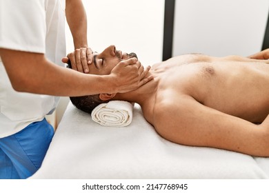 Two hispanic men therapist and patient having facial massage at beauty center - Powered by Shutterstock