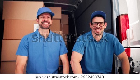 Two Hispanic Movers Unloading Boxes After Successful Moving Day Smiling