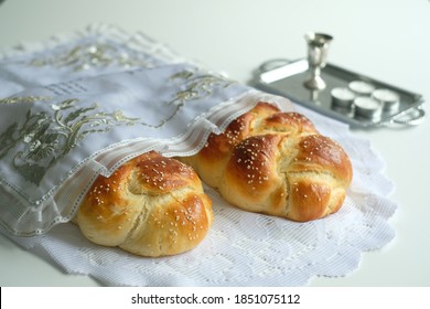 Two homemade Halas with candles on a white background for Shabbat - Shutterstock ID 1851075112