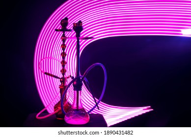 Two Hookahs With Shisha Coals Pink Neon Lighting On A Dark Background