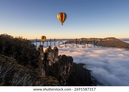 Two hot air balloons float over Three Sisters landmark Blue Mountains, Katoomba in the early morning