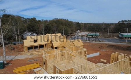 Two houses under construction with building envelope and wooden frame beam, joist, trusses framework, gable roof in suburban area of Flowery Branch, Georgia, USA. Aerial view unfinished homes