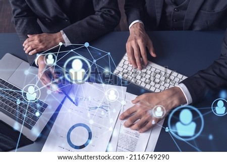 Two HR specialists man and woman analyzing the market of alumni to boost the intern program at international consulting company. Hiring new talented officers. Social media hologram icons.