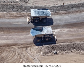 Two huge CAEX dump trucks crossing paths during the mineral transport process