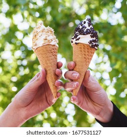 Two Ice Cream Cones In The Hands.
