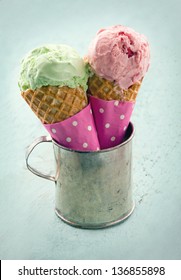 Two Ice Cream Cones In An Old Metal Mug On Blue Shabby Chic Vintage Background