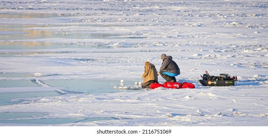 Two ice fishermen teaming for the day with the needed equipment.  Small Boat Harbor.  Buffalo, New York, USA, January 31st, 2022