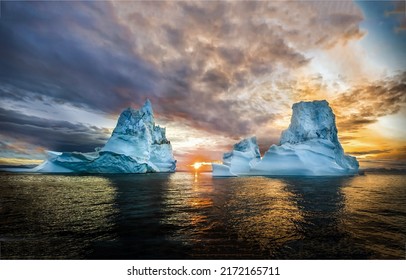 Two icebergs in the ocean at dawn. Iceberg at dawn. Beautiful sunrise over sea iceberg. Two iceberg at dawn