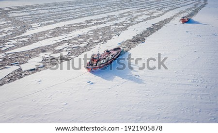 Two icebreakers on Vistula river crush the ice in winter, aerial view of Poland