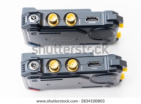 Two identical electronic devices with multiple ports are shown on white