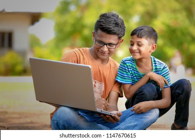 Two Indian brothers working on laptop - Shutterstock ID 1147670615